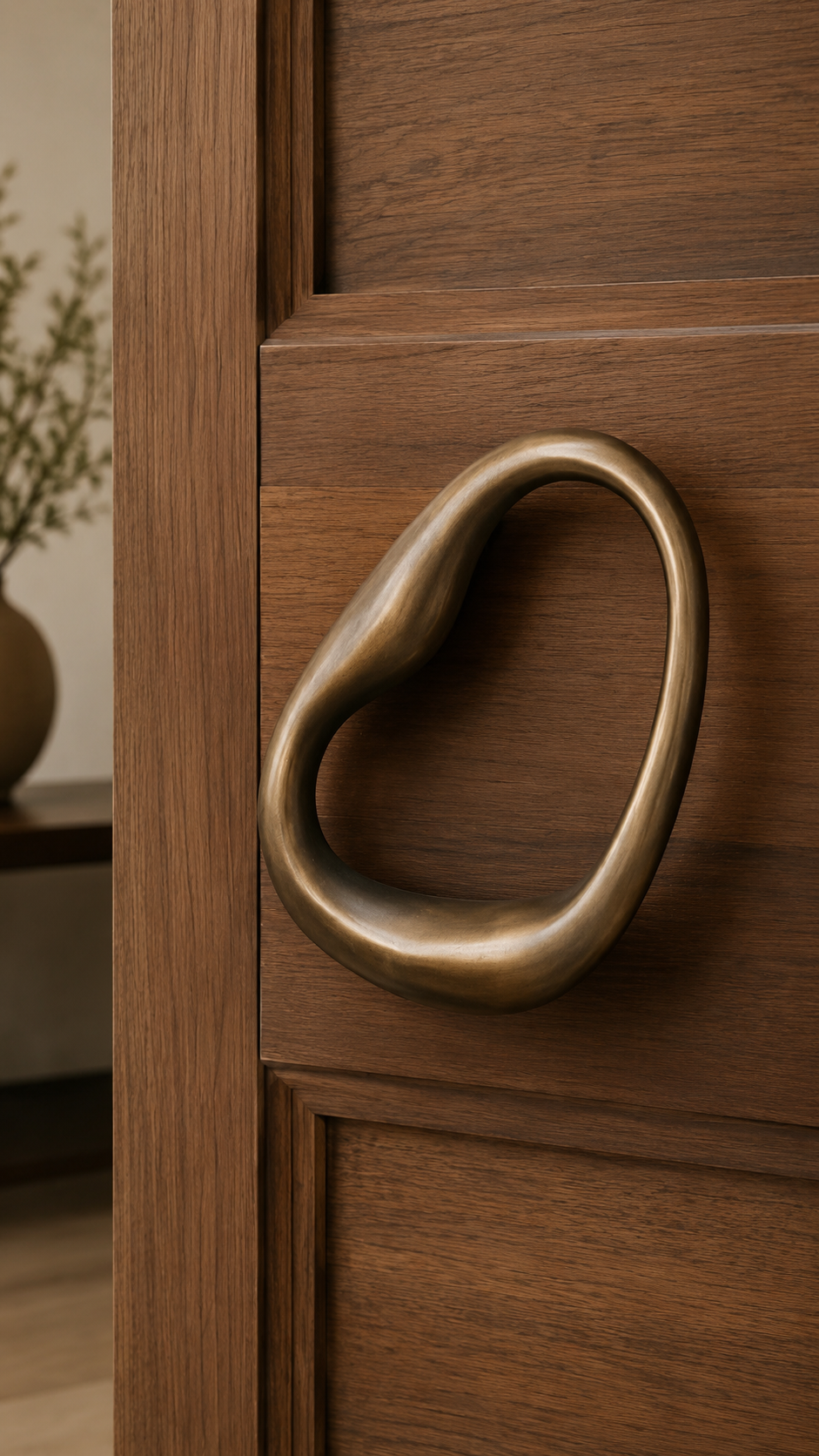 Rectangular brushed gold door handle on dark paneled door with geometric detail, sharp edges, and luxury modern hardware