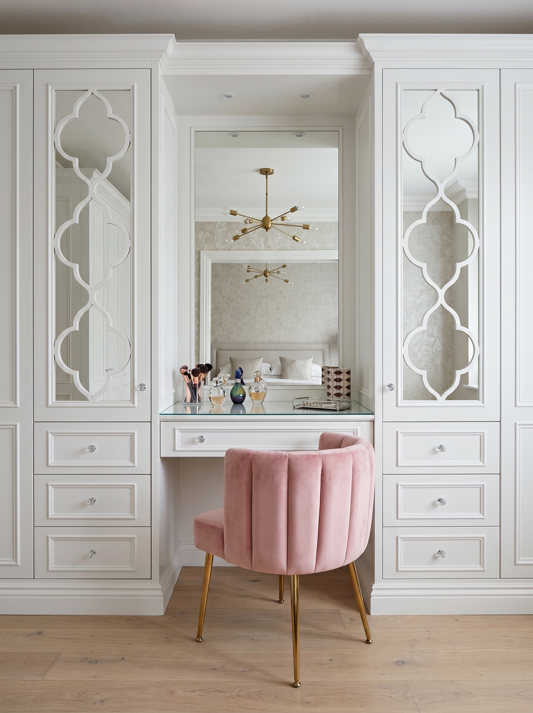 Glossy white wardrobe with vanity, pink wall panels, round LED mirror, mirrored doors, gold handles, open shelves, and pink chair