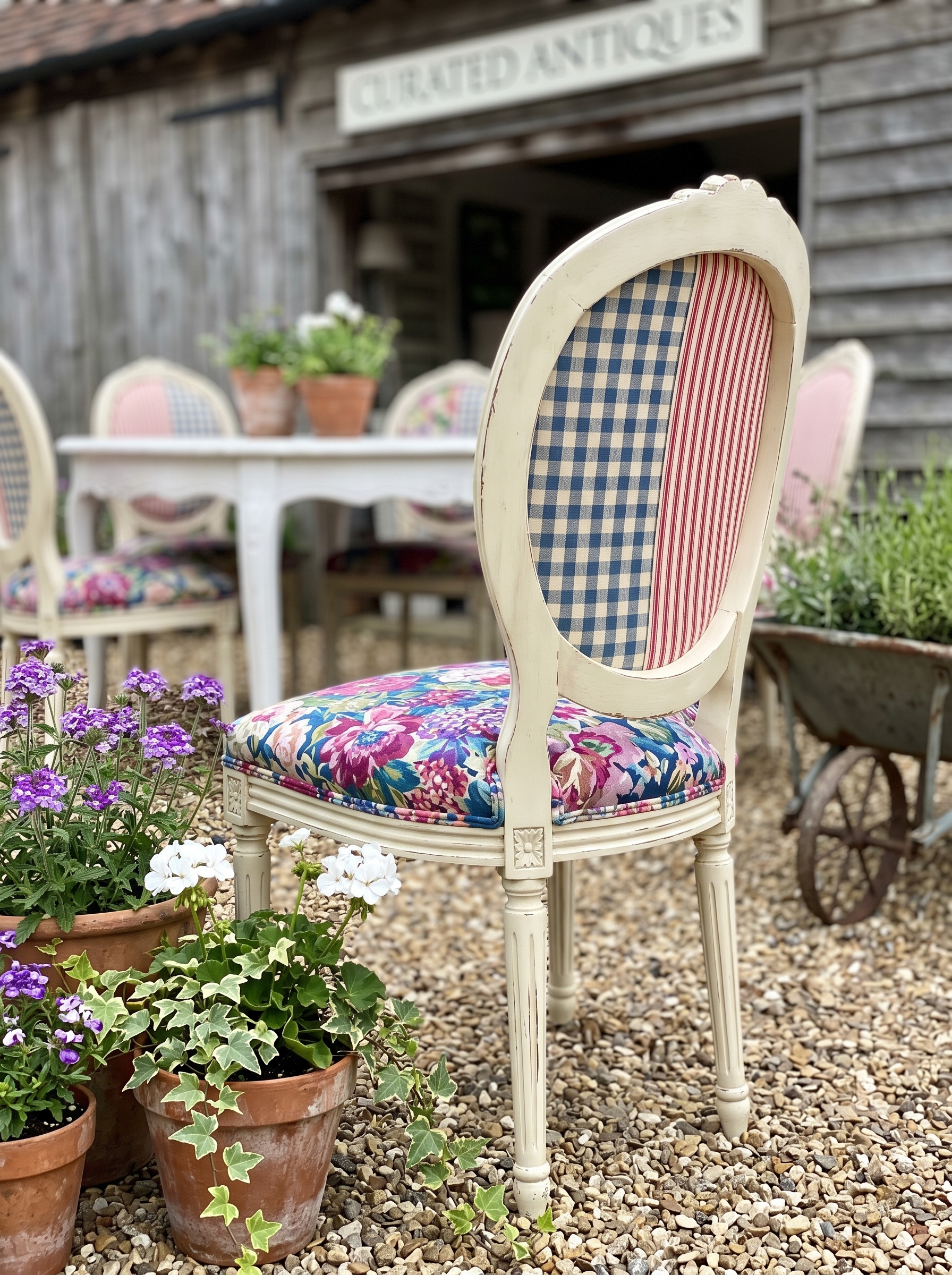 Blue foldable outdoor dining chair with striped cushion, mustard throw, coral side table, wooden deck, and small balcony decor