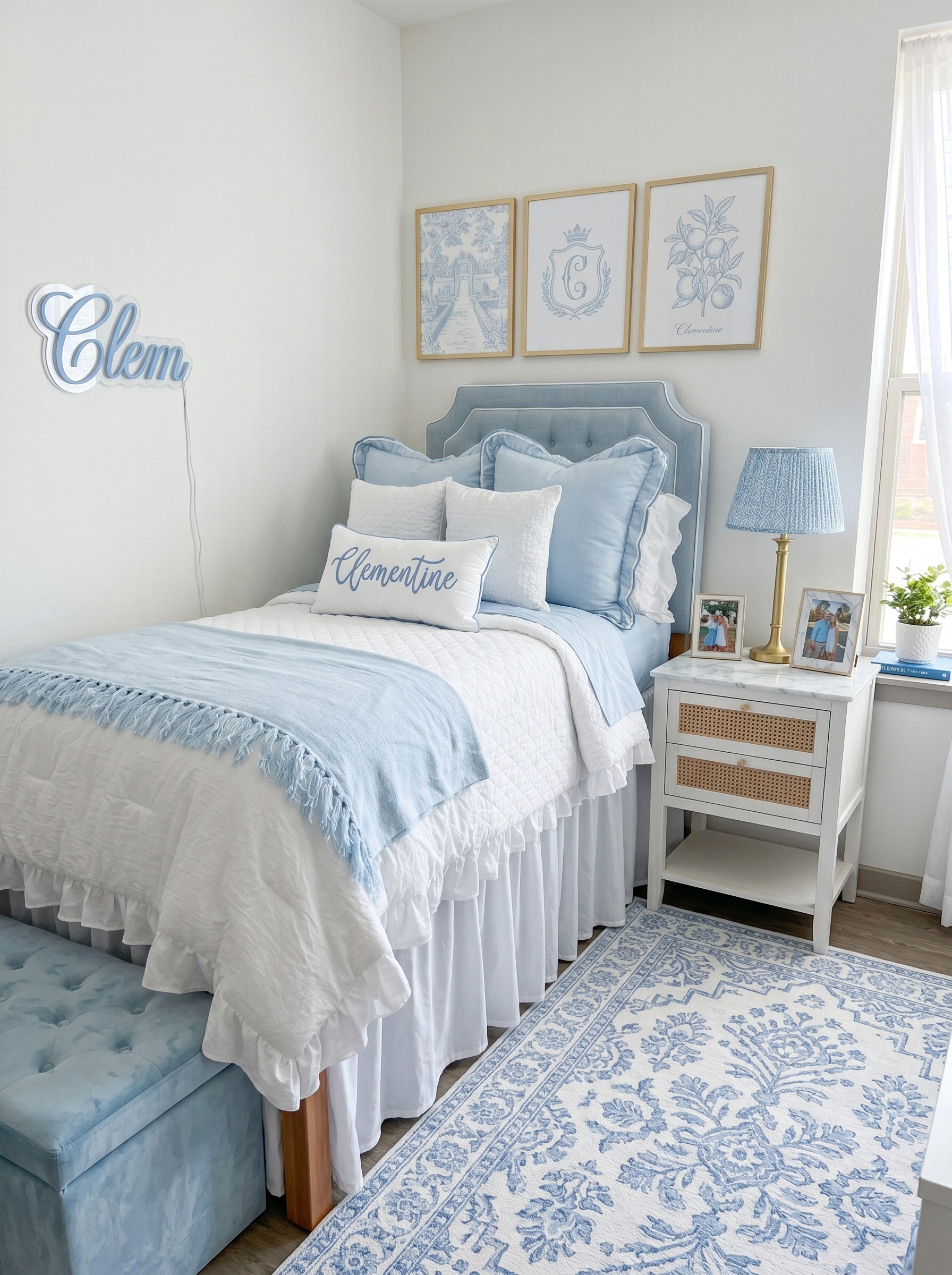 Soft coastal blue dorm room with white bedding, blue knit blanket, photo wall, ivy garlands, string lights, and storage ottoman