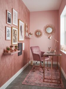 Cozy corner small home office with wooden desk, floating shelves, indoor plants, brass lamp, books, and natural window light